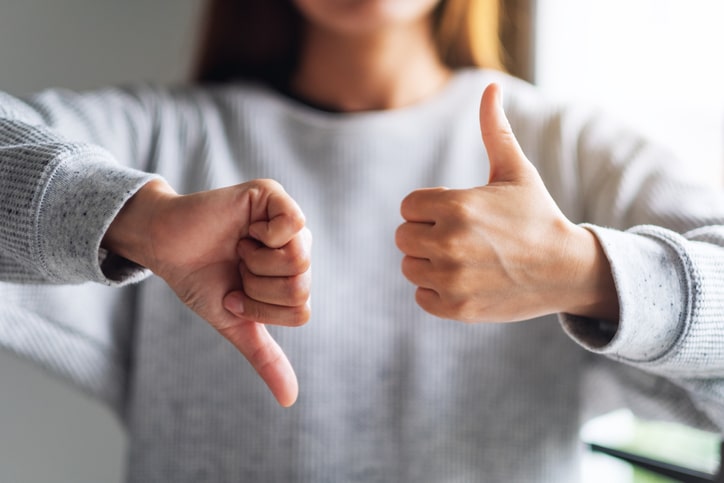 Woman with one thumb up and one thumb down